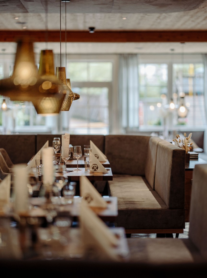 Stilvoll eingerichtetes Restaurant mit eleganten Lampen und gedeckten Tischen
