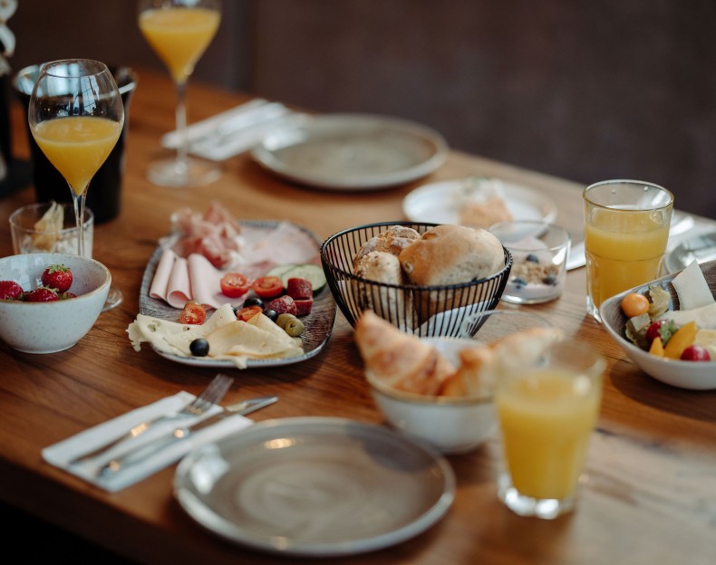 Frühstückstisch im Resl Resort mit Saft, Brötchen, Wurst, Käse und Obst