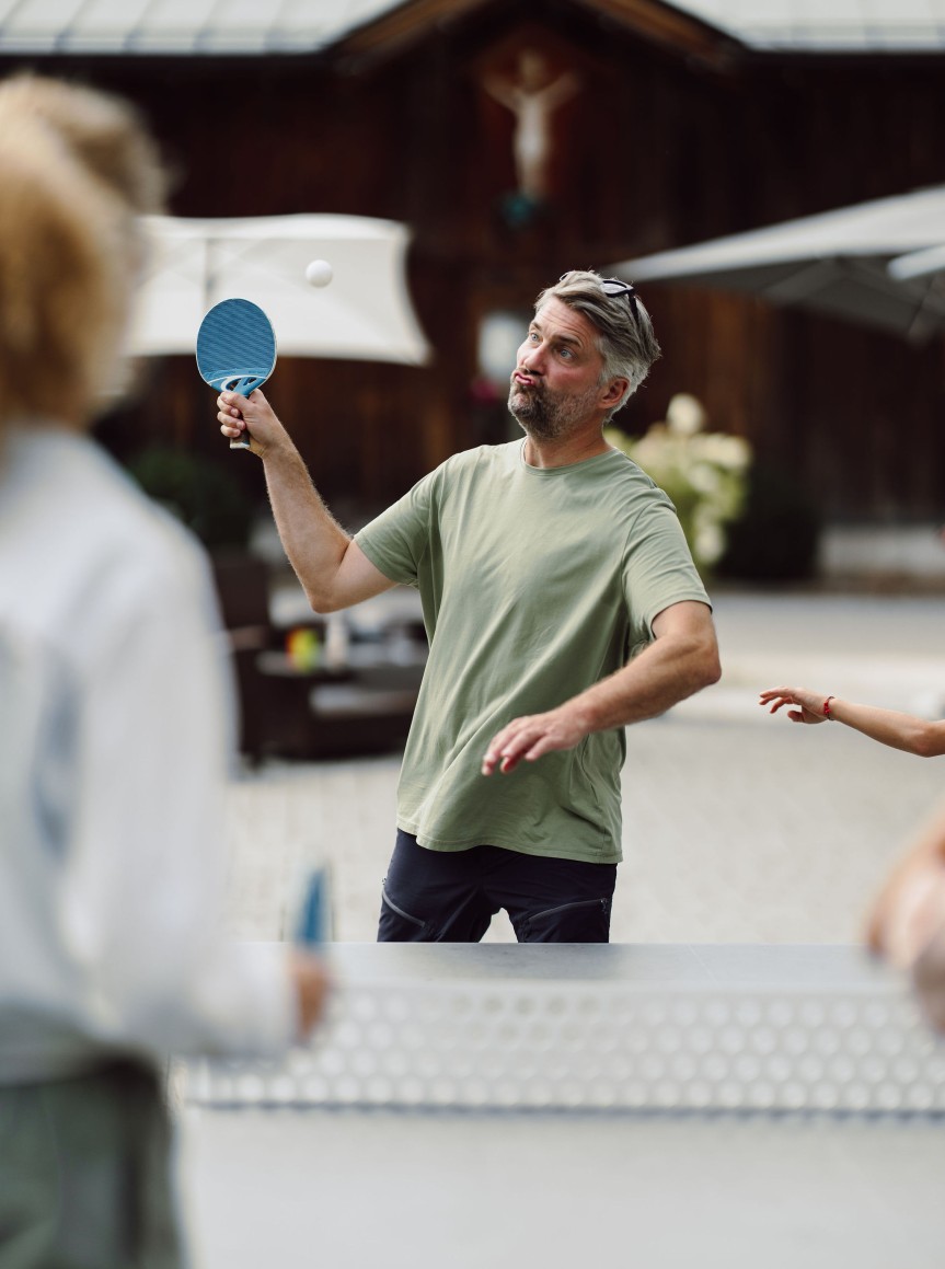 Familie spielt Tischtennis in Außenbereich