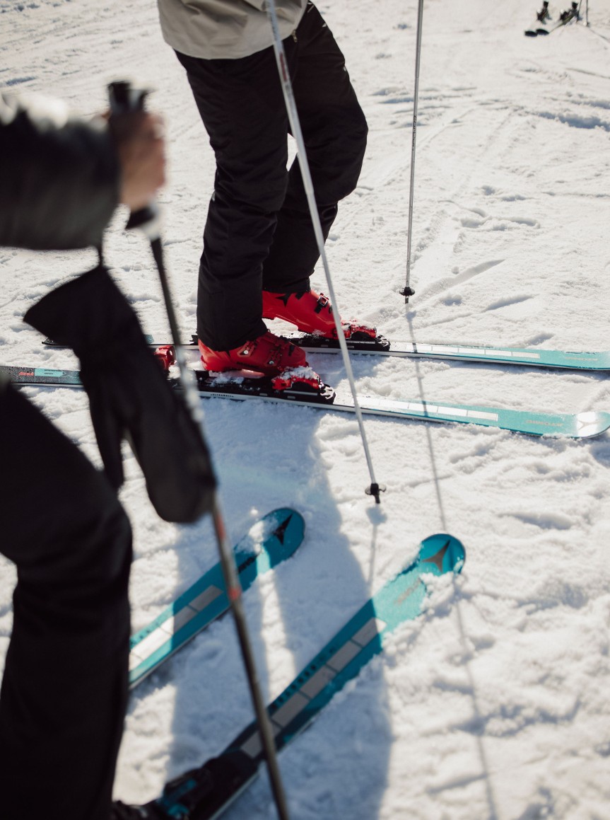 Zwei Personen stehen mit Skiern und Skistöcken auf Schnee