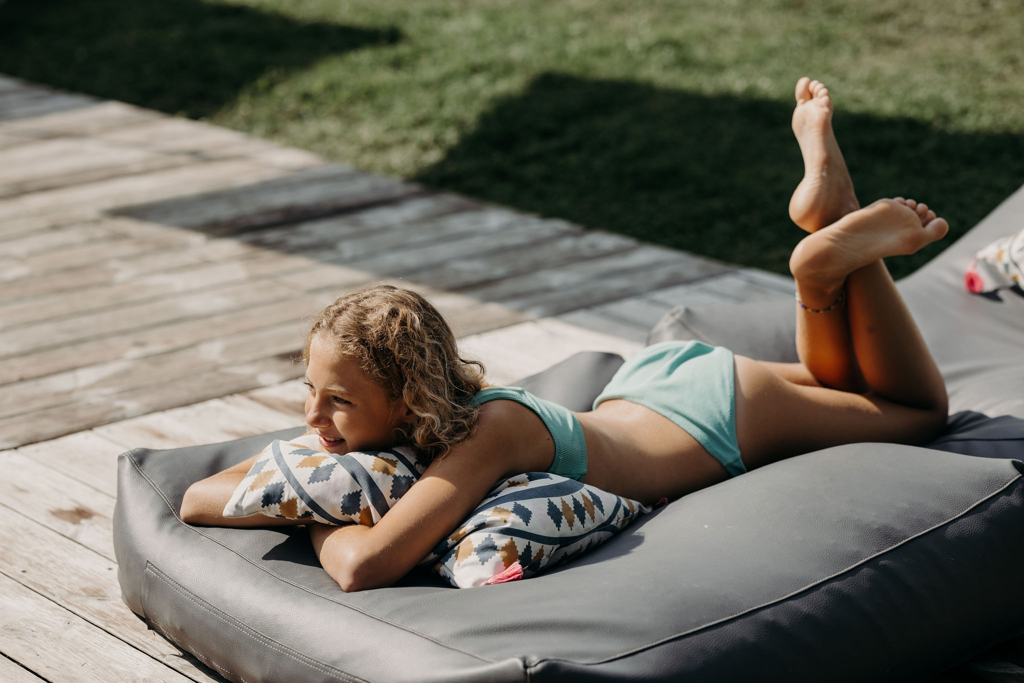 Ein Kind entspannt sich auf einem Kissen im Freien und genießt die Sonne