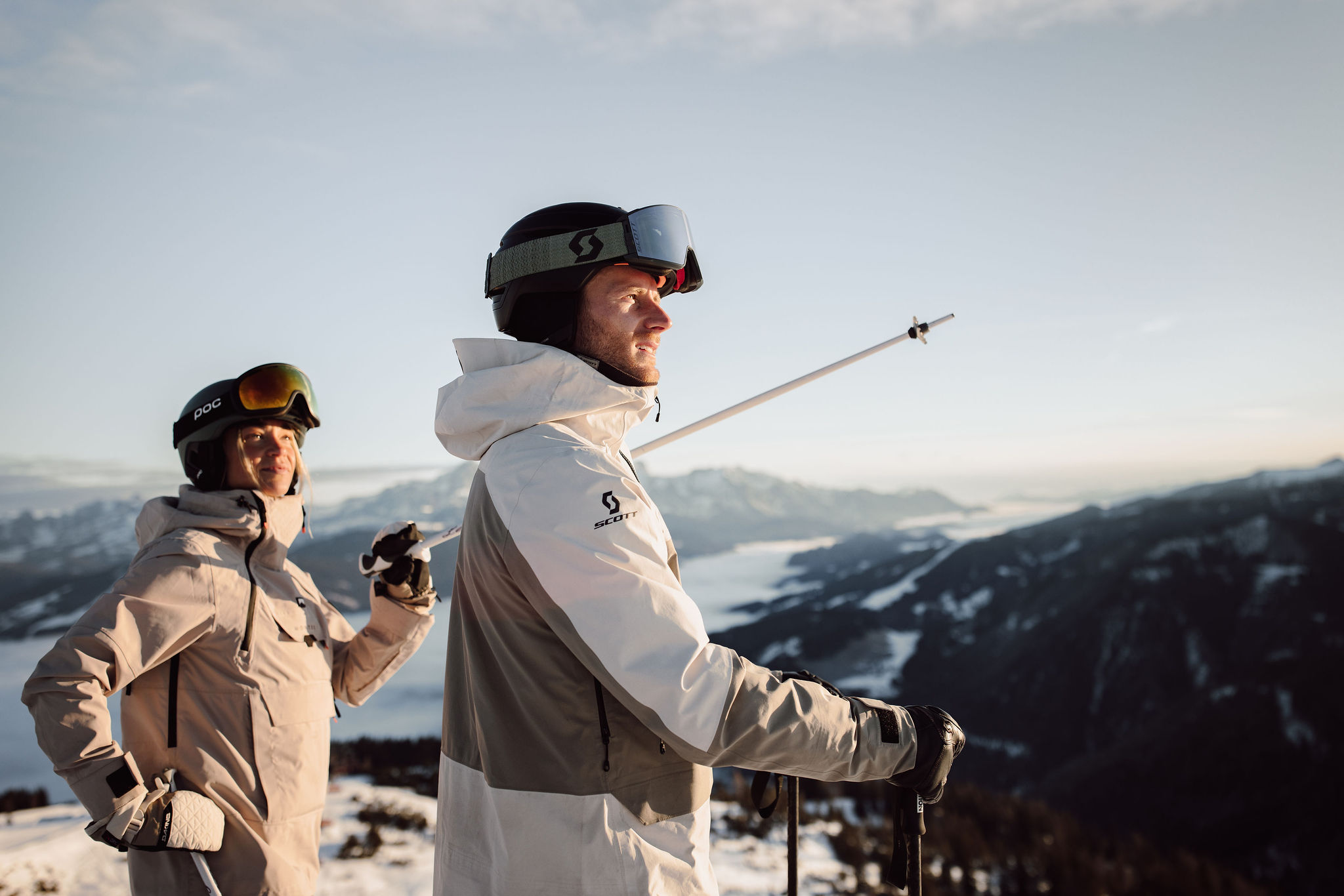 Zwei Skifahrer in Winterkleidung genießen die Aussicht auf verschneite Berge