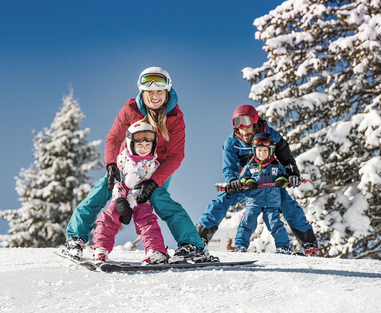 Familie mit Kindern fährt Ski im Schnee beim Winterurlaub im Reslwirt Flachau