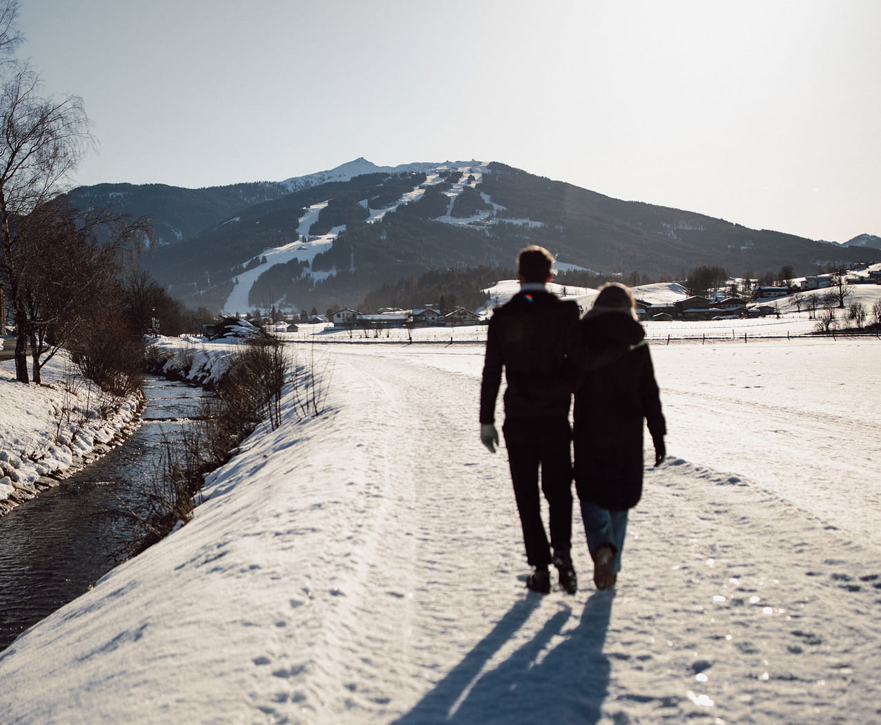 Paar beim romantischen Winterspaziergang in Flachau – Urlaub im Reslwirt
