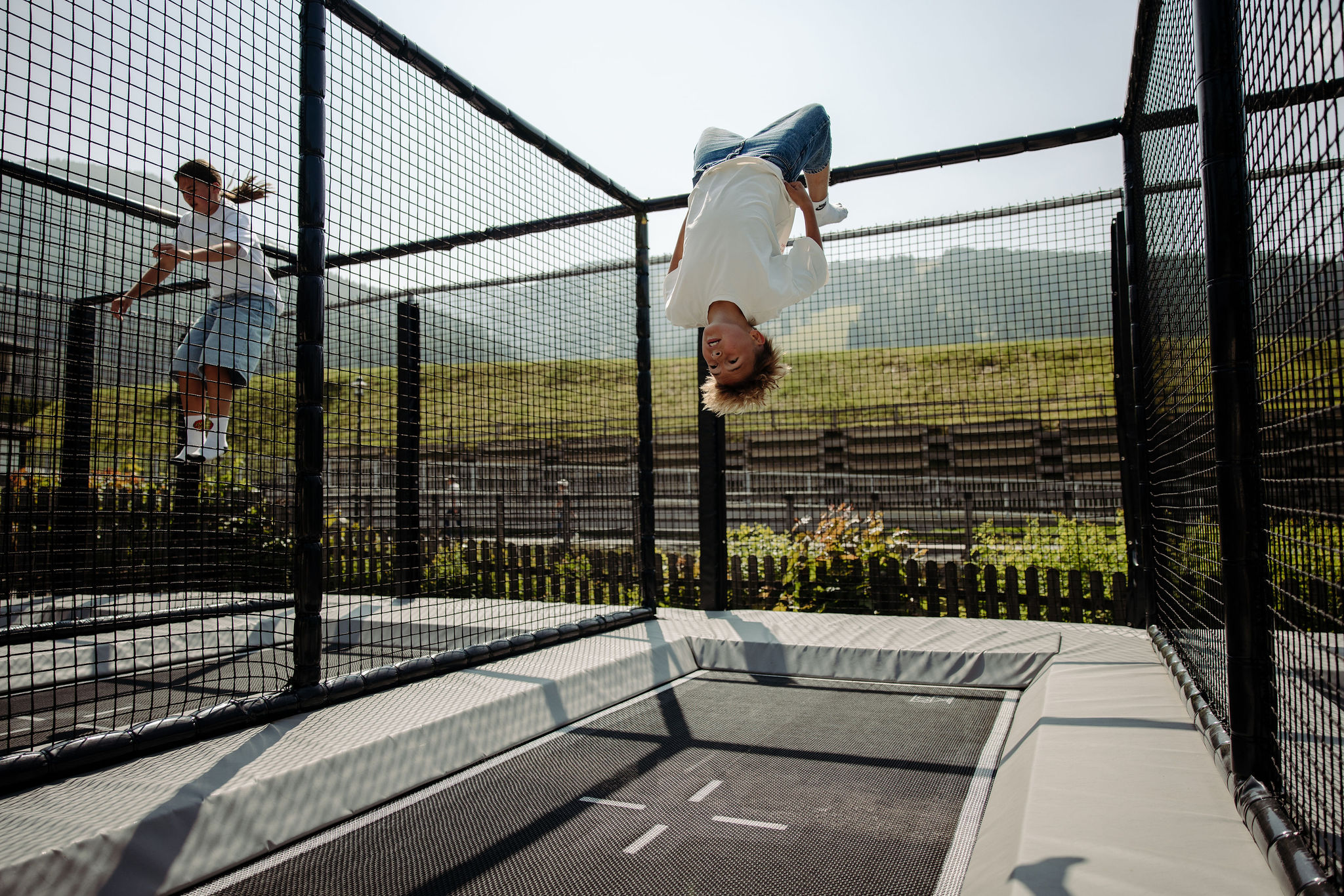 Kind macht einen Salto auf einem gesicherten Outdoor Trampolin im Resl Resort
