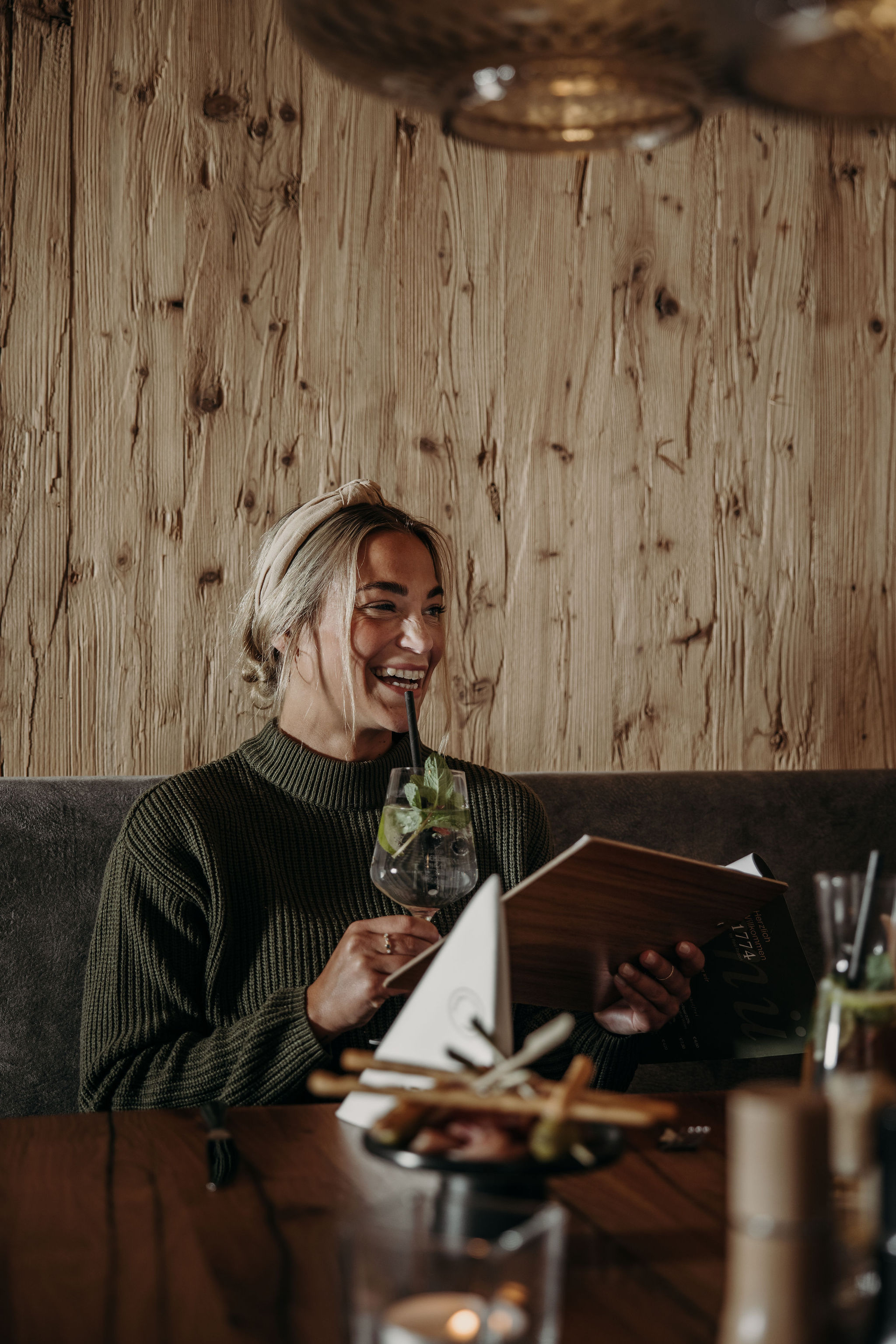 A smiling person holding a drink and enjoy in hotel restaurant