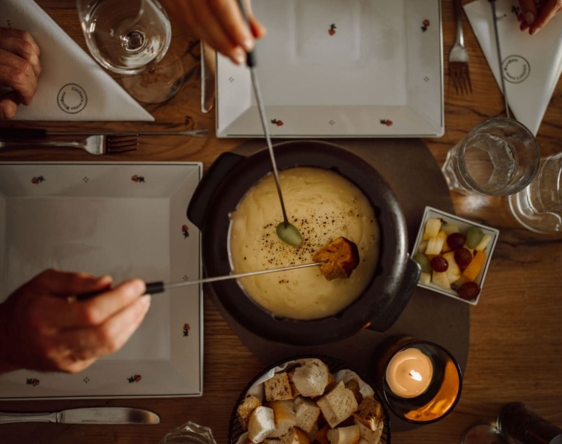 Gesellige Fondue-Runde im Ennshof mit Kerzen, Wein und Fondue