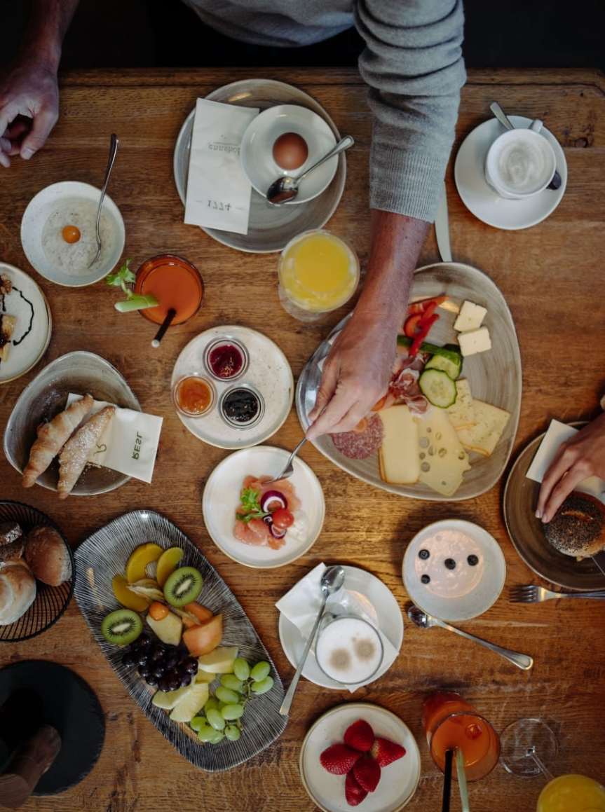 Ein reichhaltiges Frühstück auf einem Holztisch im Restaurant des Hotel Resl in Flachau