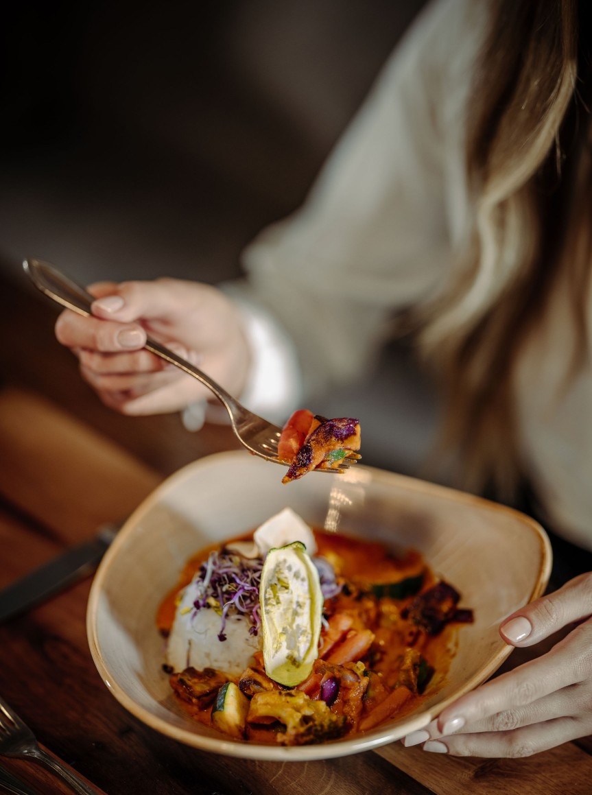 Person genießt buntes Curry im Hotel Resl in Flachau