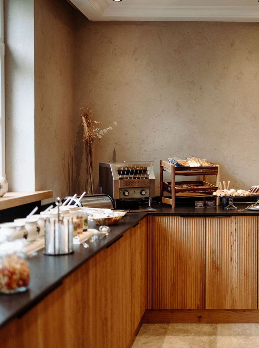 Ein modernes Frühstücksbuffet mit Toast, Gebäck und einem Toaster im Hotel Resl in Flachau