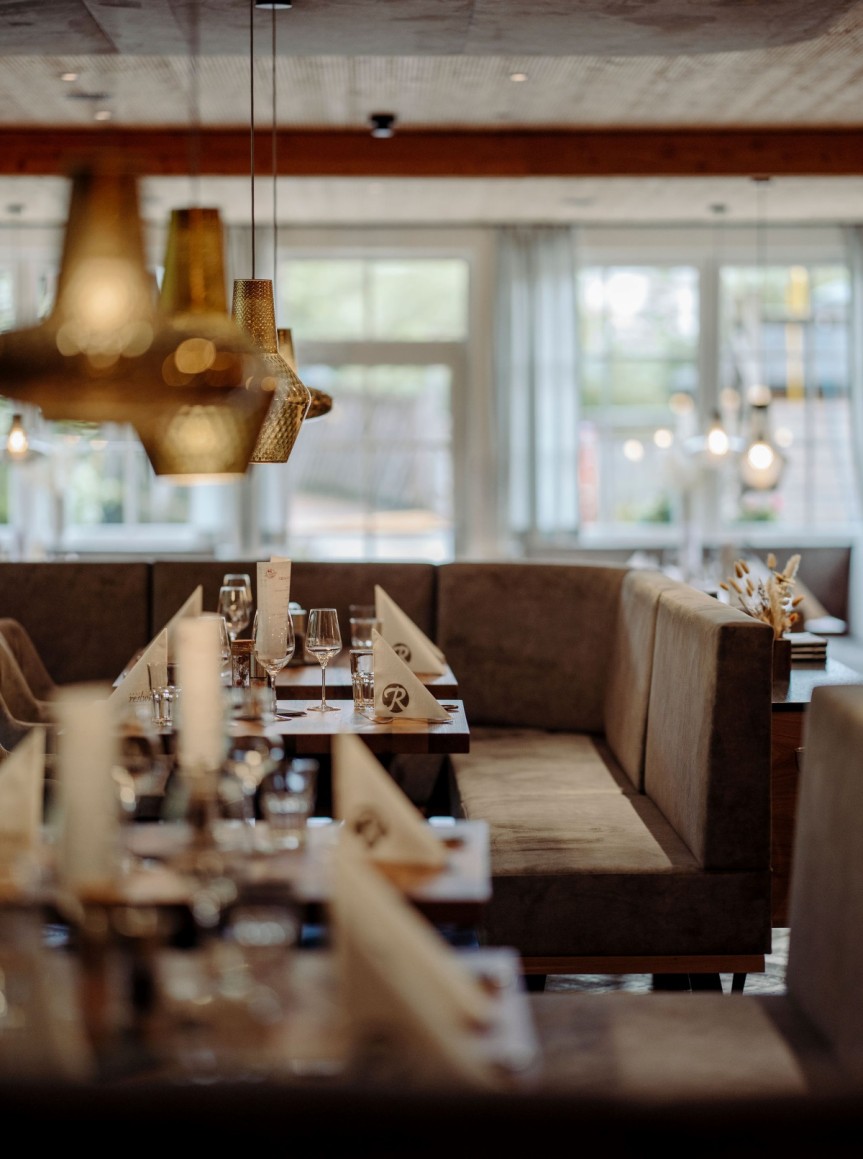 Elegantes Restaurant mit gedeckten Tischen und moderner Beleuchtung