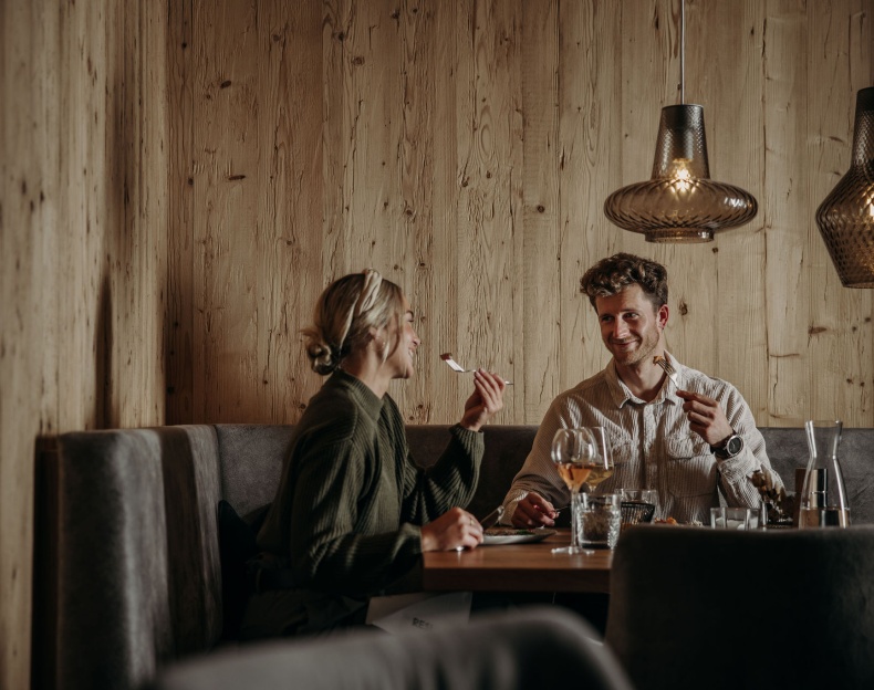 Stilvoll eingerichtetes Restaurant mit Holzdekor und gedeckten Tischen im Resl Resort