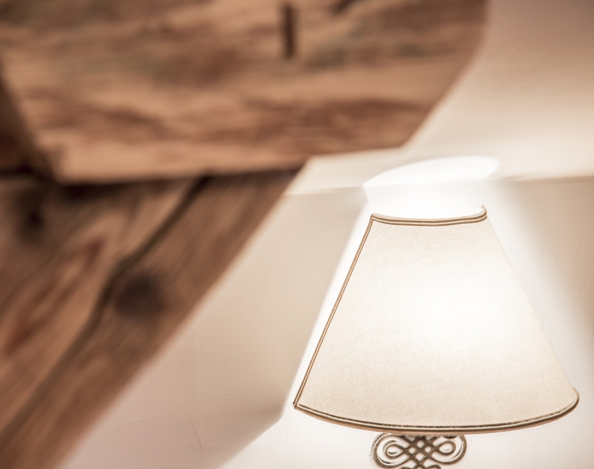 Eine Wandlampe mit einem stoffbedeckten Schirm im Schneiderhäusl