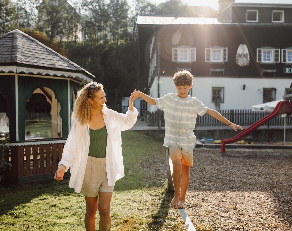 Familie übt ein Balancier Spiel im Garten des Familienhotels Resl