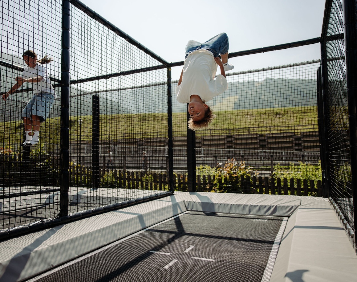 Junge macht einen Sprung auf der Outdoor-Trampolinanlage