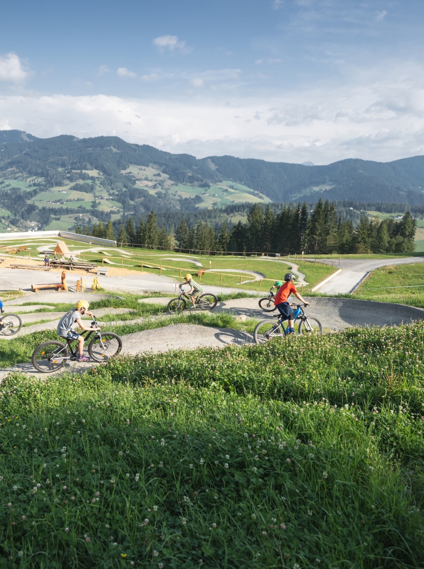 kinder fahren Rad am Berg in einem Parcour