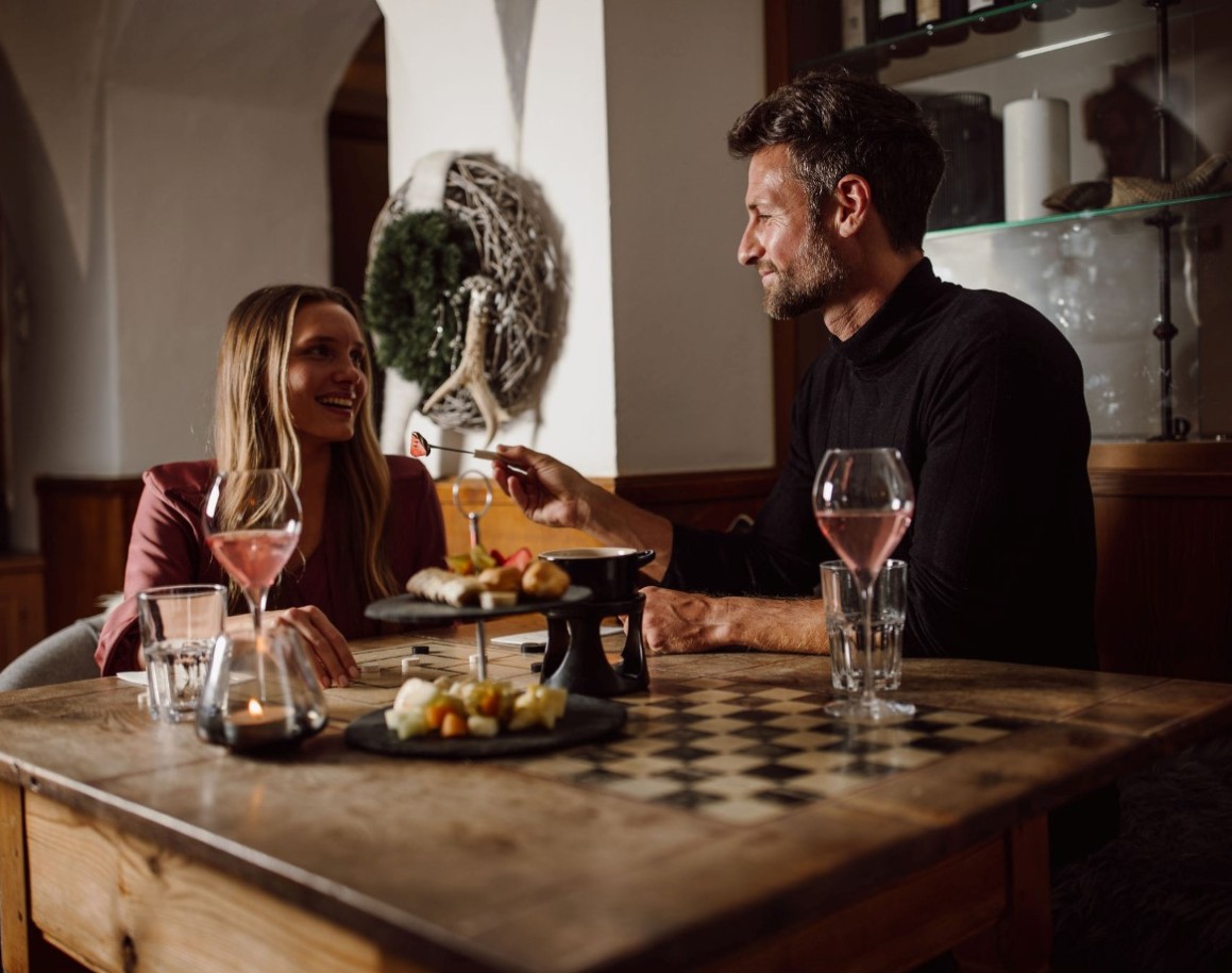 Paar genießt ein Essen im Fondue-Restaurant in Flachau