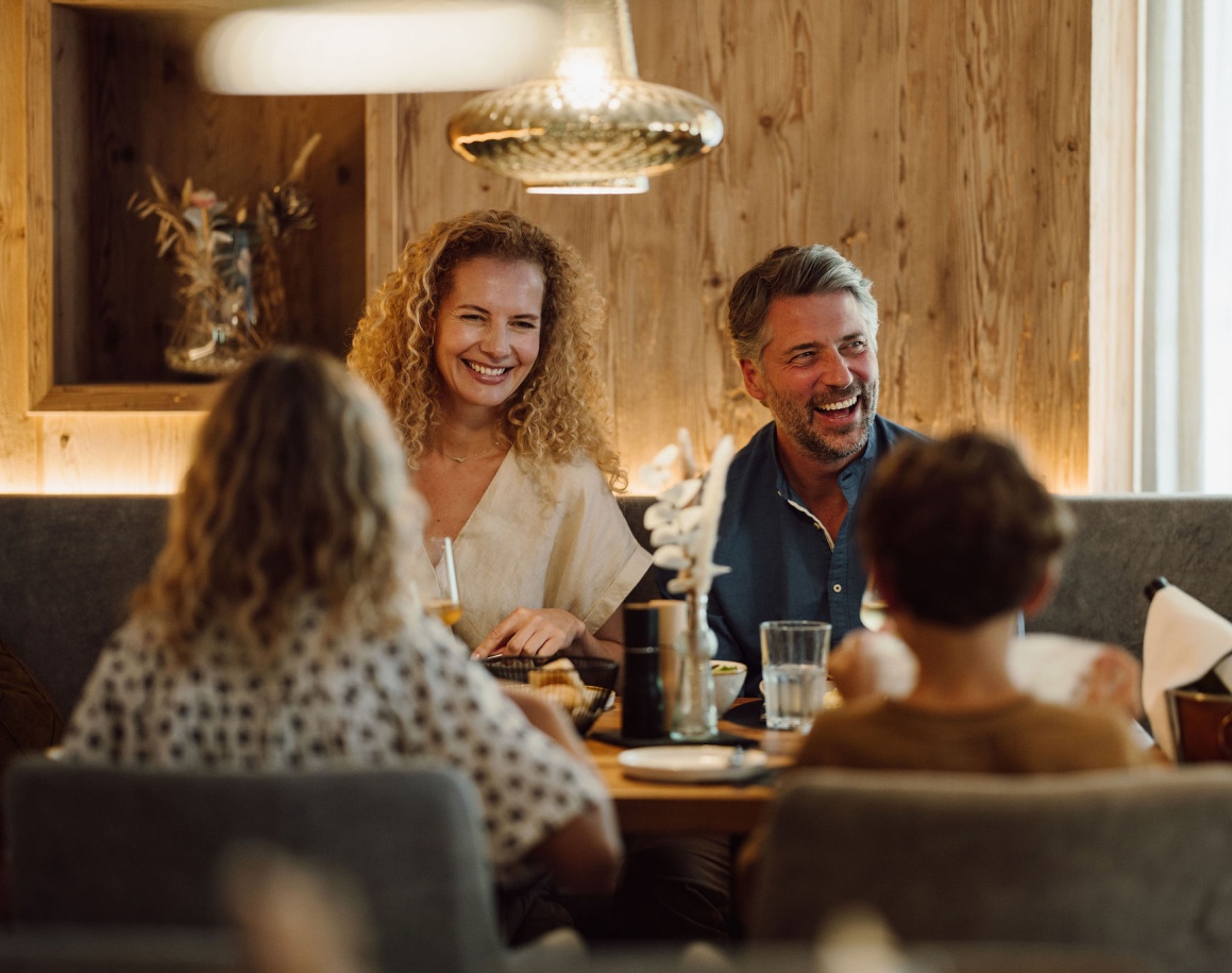 Eine fr&ouml;hliche Familie sitzt zusammen an einem Tisch in einem gem&uuml;tlichen Restaurant