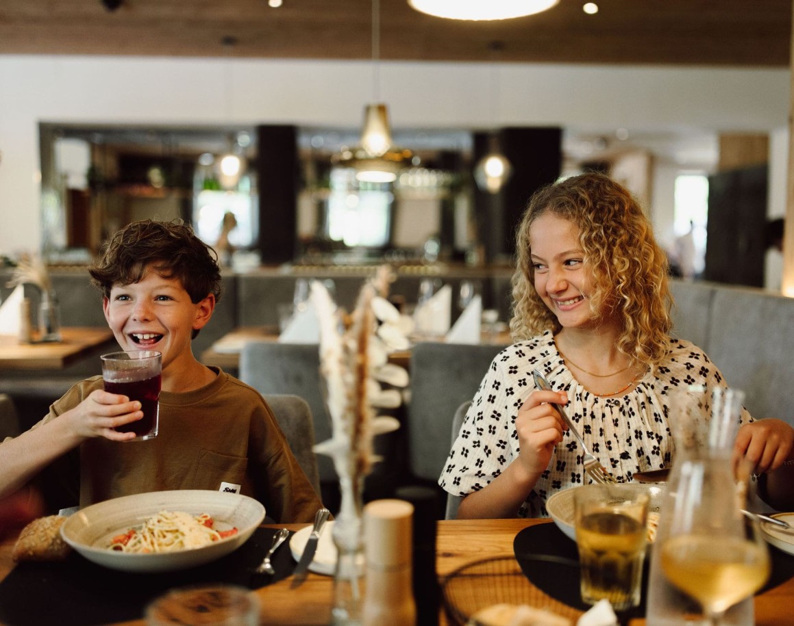 Zwei Kinder essen und lachen gemeinsam im Hotel Resl