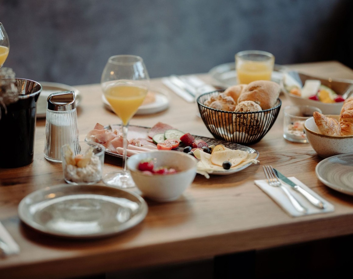 Reich gedeckter Frühstückstisch mit Getränken und Obst