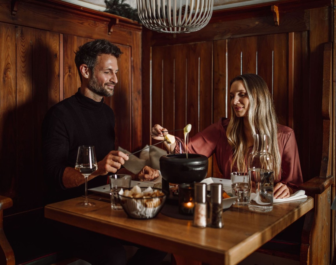 Paar genießt ein Käsefondue im Fonduerestaurant Ennshof