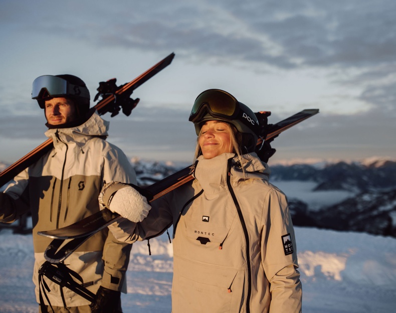 Skifahrer stehen am Berg auf der Piste und genie&szlig;en die Sonne