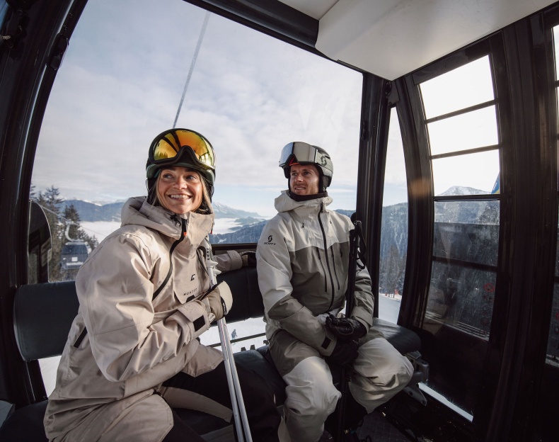 Zwei Personen in Skiausr&uuml;stung genie&szlig;en sonniges Wetter im Schnee