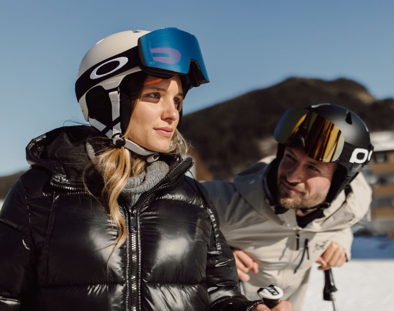 Zwei Personen in Skiausrüstung genießen sonniges Wetter im Schnee