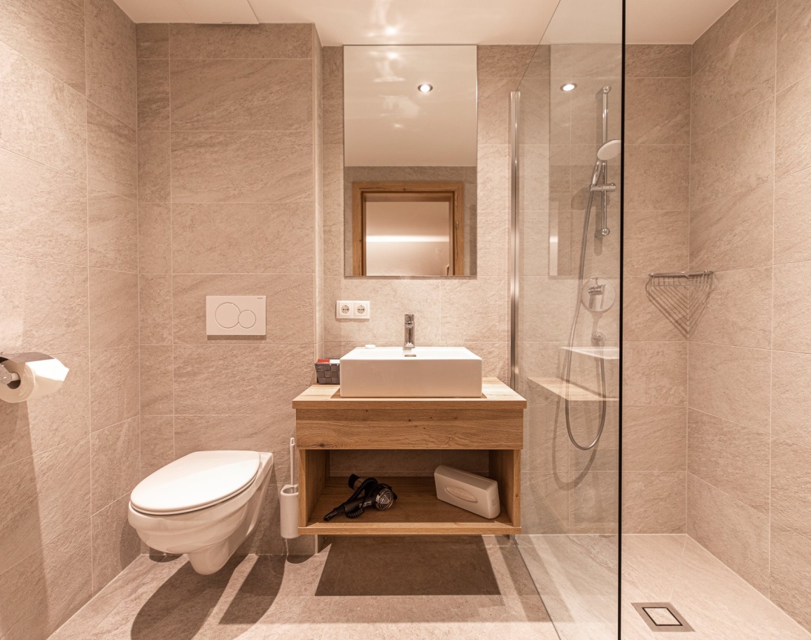 Helles Badezimmer mit Waschbecken, Spiegel und Toilette