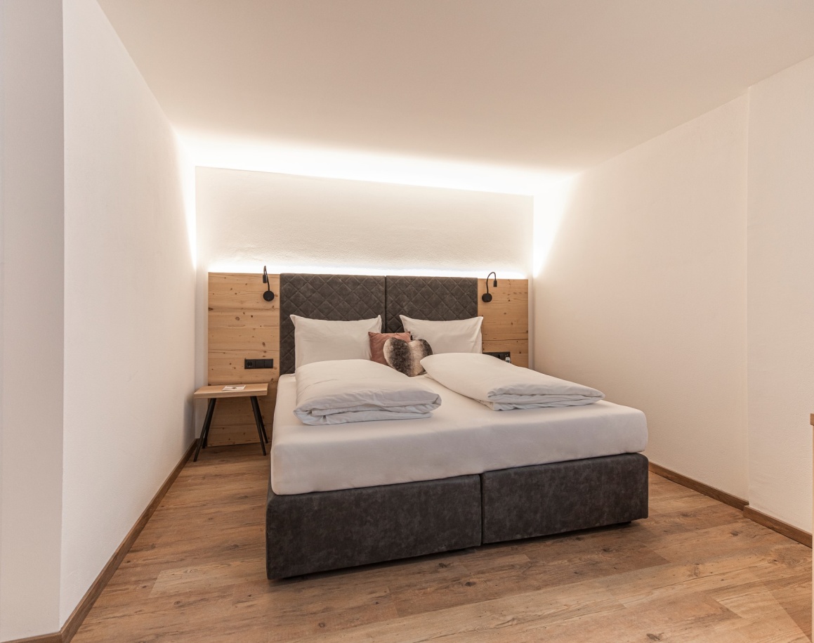 Modernes Hotelzimmer mit Doppelbett und indirekter Beleuchtung