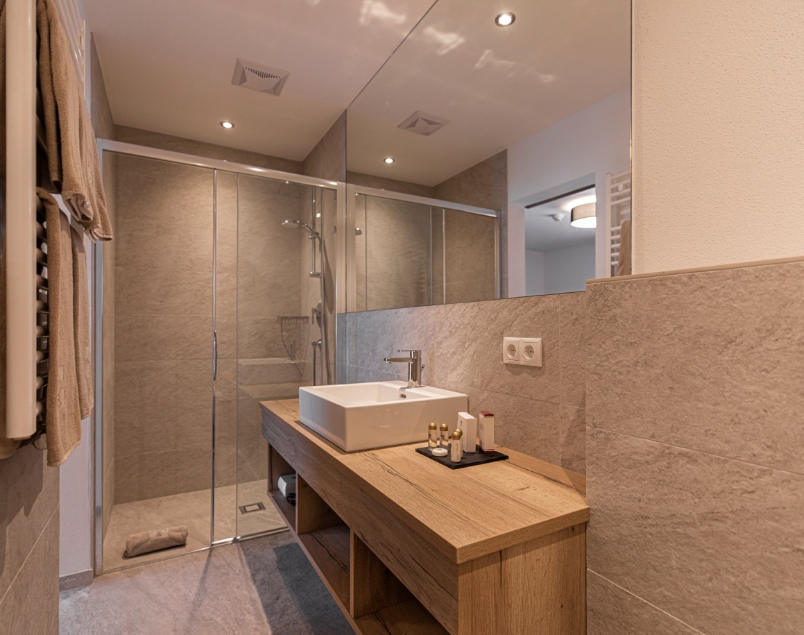 Modernes Badezimmer mit Glasdusche, Waschbecken und Spiegel