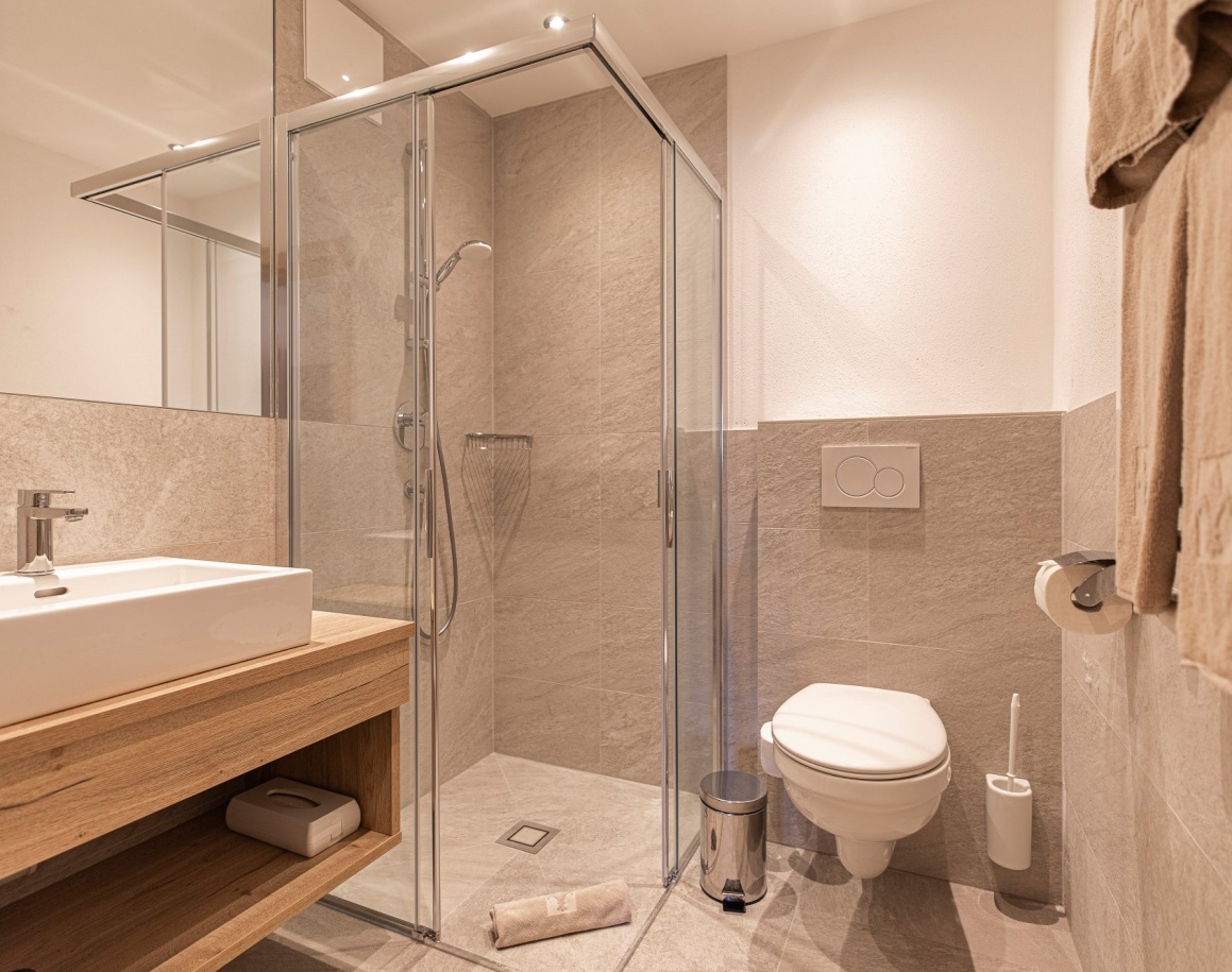 Helles Badezimmer mit Dusche, Waschbecken und Toilette