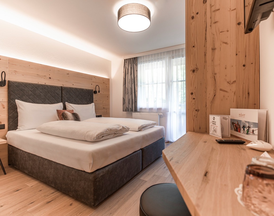 Gemütliches Hotelzimmer mit Doppelbett, Schreibtisch einem großen Fenster