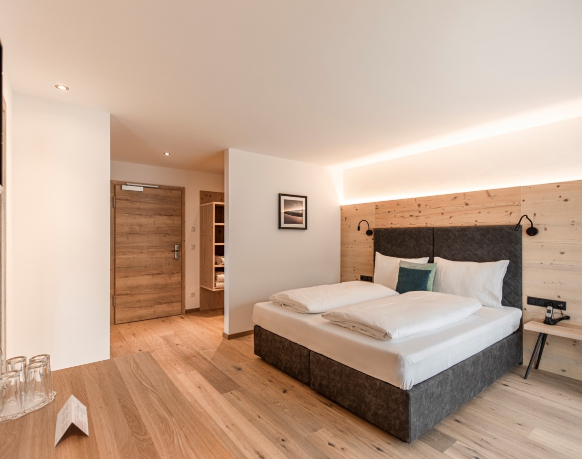 Modernes Hotelzimmer mit Doppelbett und Holzakzenten