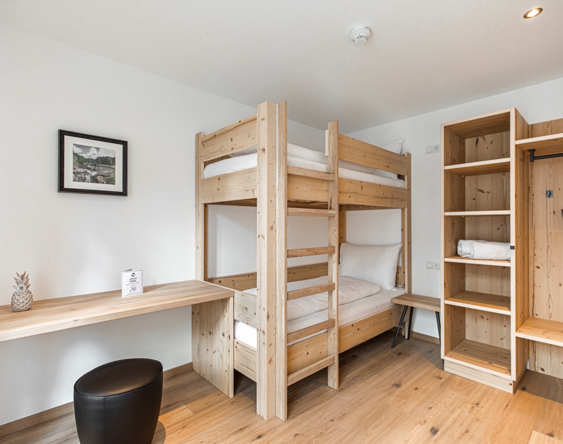 Zimmer mit Etagenbett, Schreibtisch und großem Kleiderschrank