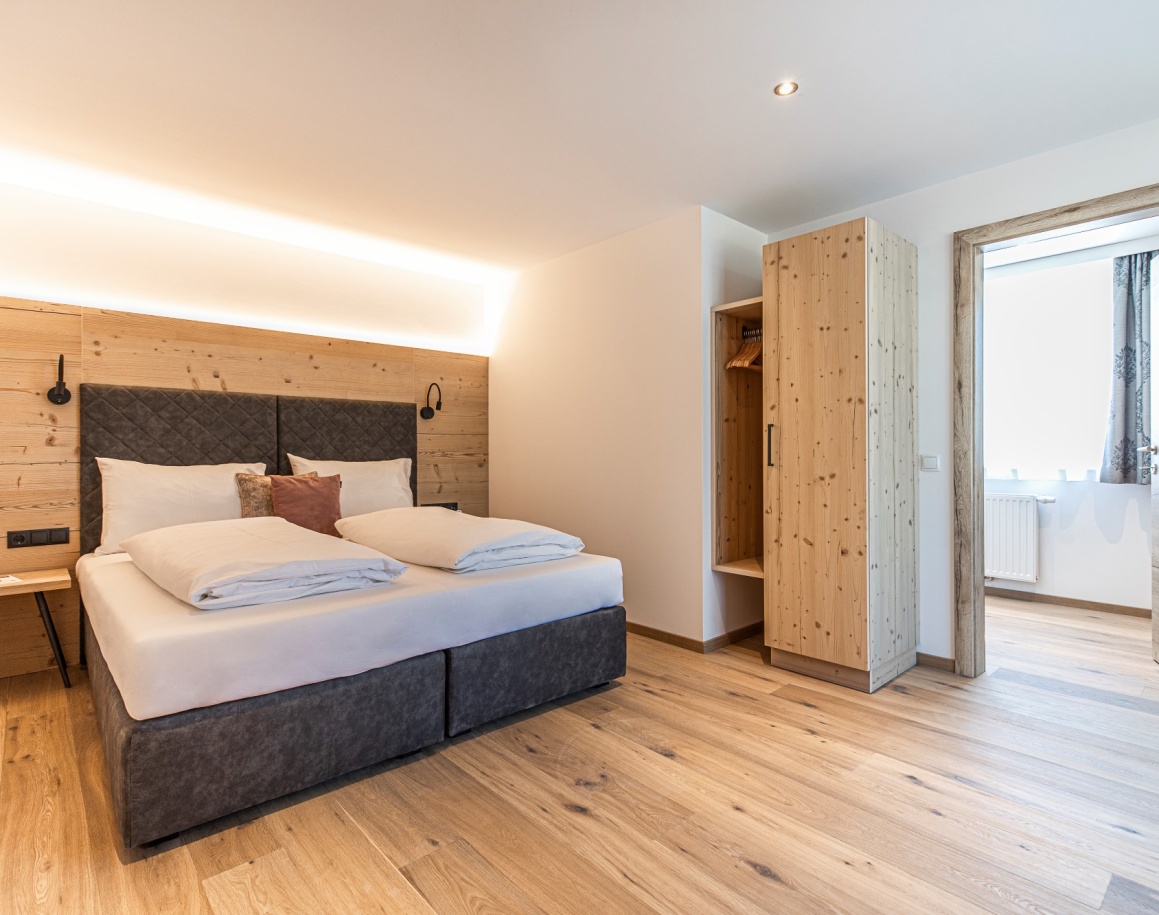 Ein modernes Schlafzimmer mit Holzelementen und einem großen Doppelbett