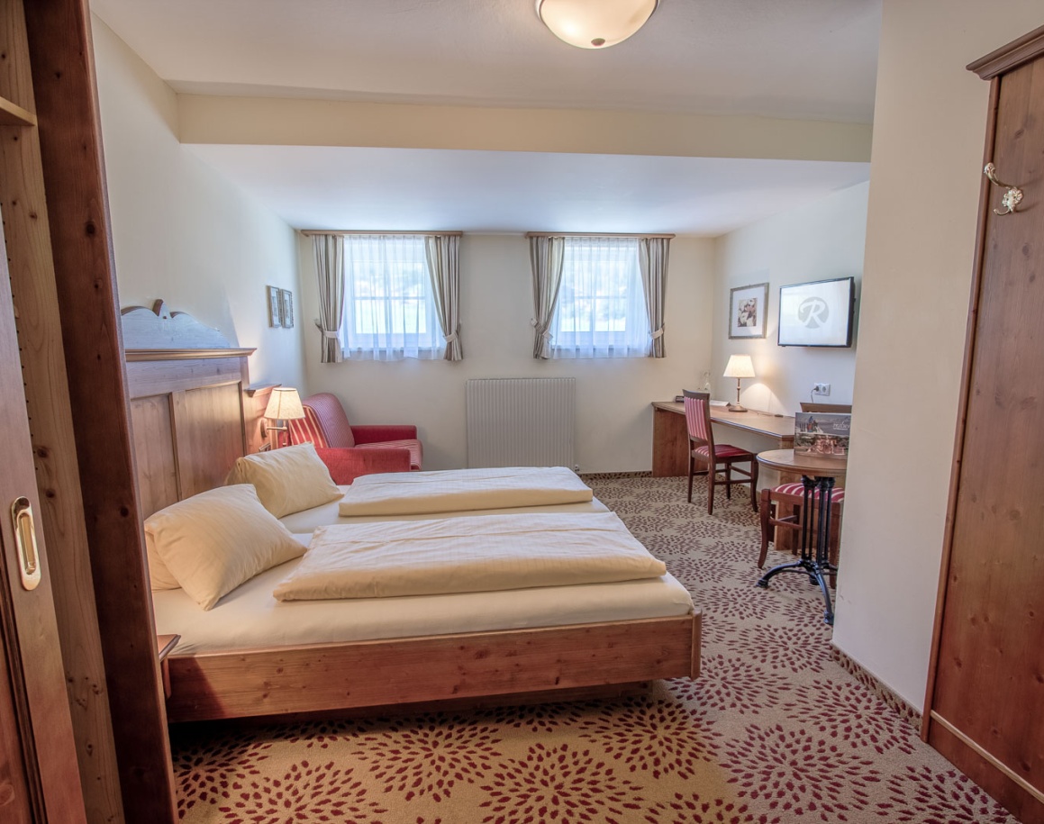 Ein gemütliches Hotelzimmer mit Doppelbett, Schreibtisch und Sofa