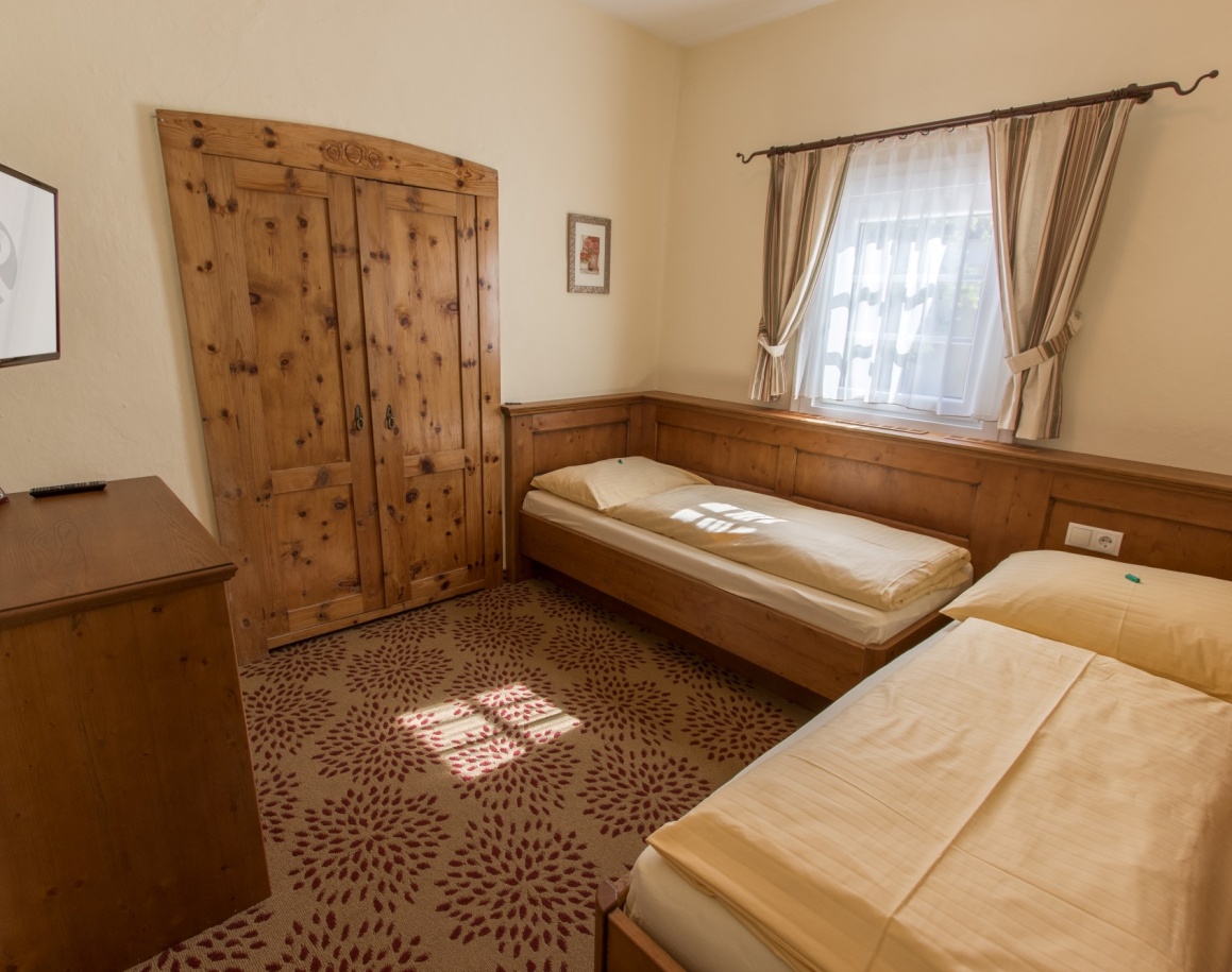 Zwei Betten in einem gemütlichen Schlafzimmer mit Holzmöbeln und Teppichboden