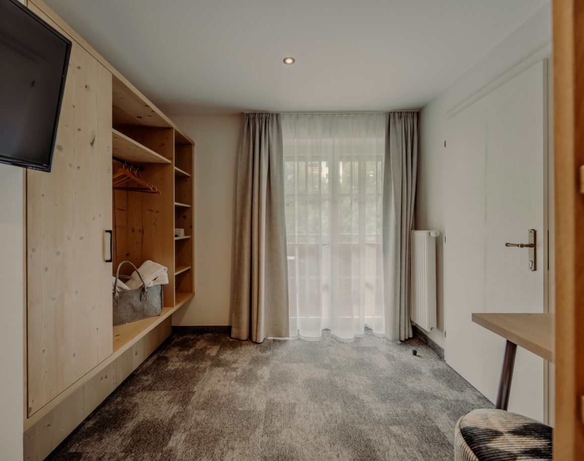 Helles Hotelzimmer mit Stockbett, Balkonblick und modernen Holzmöbeln