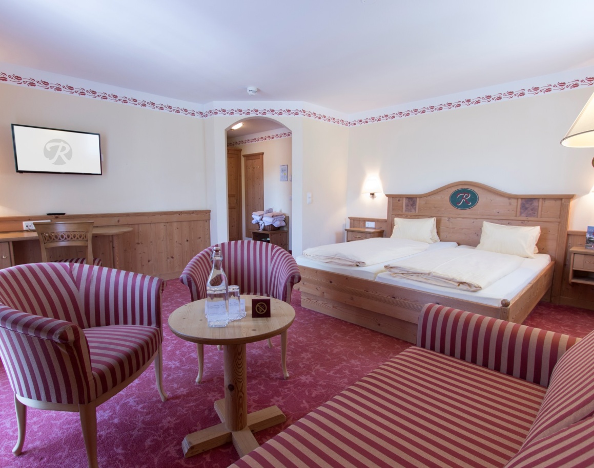 Geräumiges Hotelzimmer mit Doppelbett, Sofa und gemütlicher Sitzecke