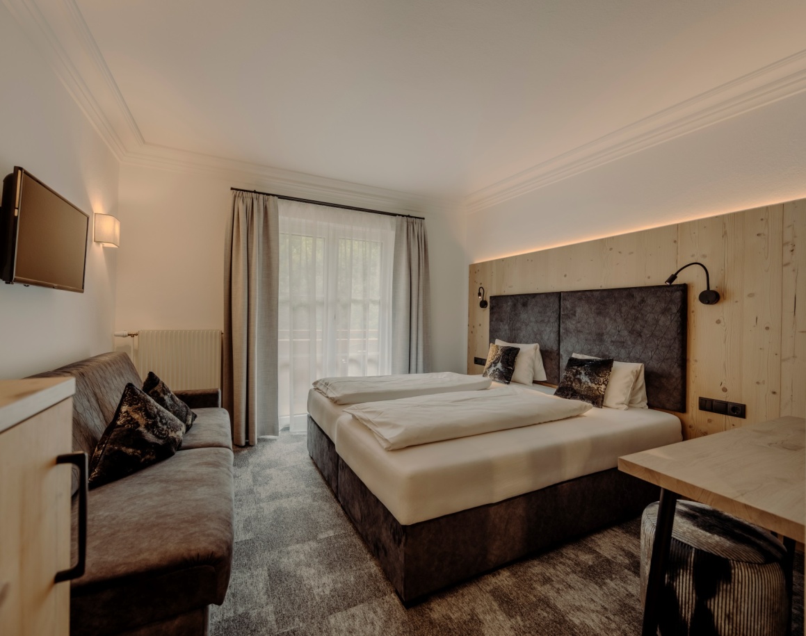 Modernes Hotelzimmer mit gemütlichem Doppelbett und Sitzecke