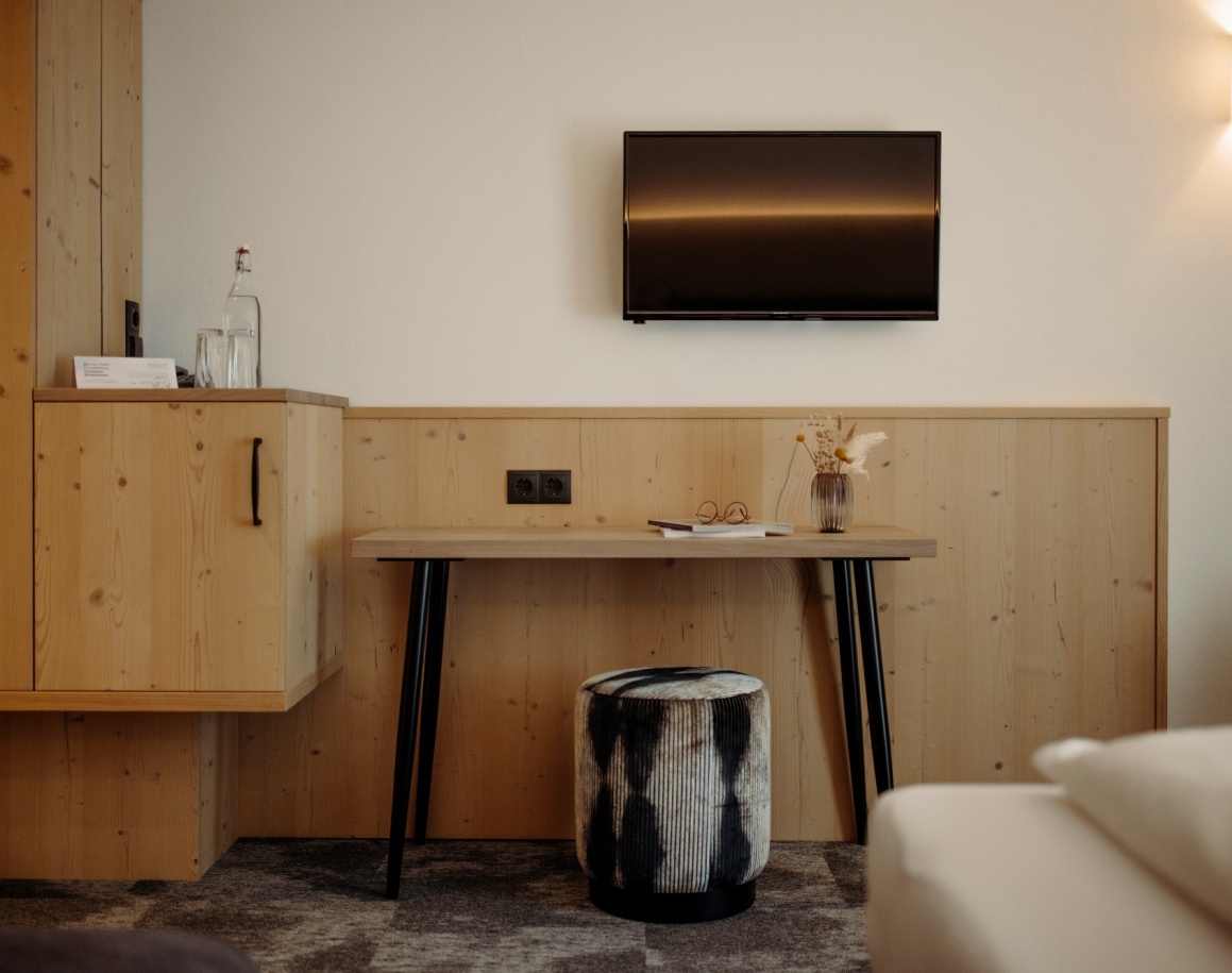 Praktische Zimmerausstattung mit Schreibtisch, TV und Hocker 