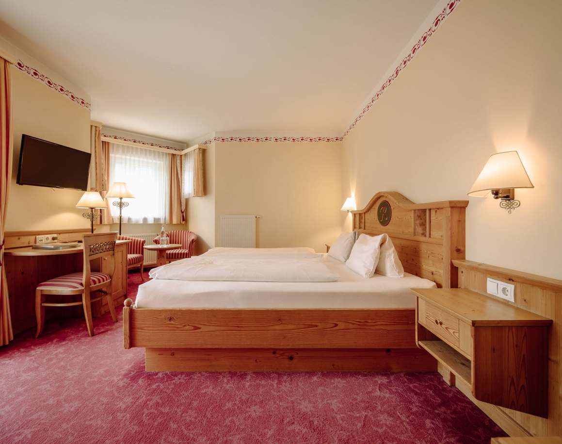 Gemütliches Hotelzimmer Resl Double Small mit Holzmöbeln, Doppelbett, Schreibtisch und Fernseher