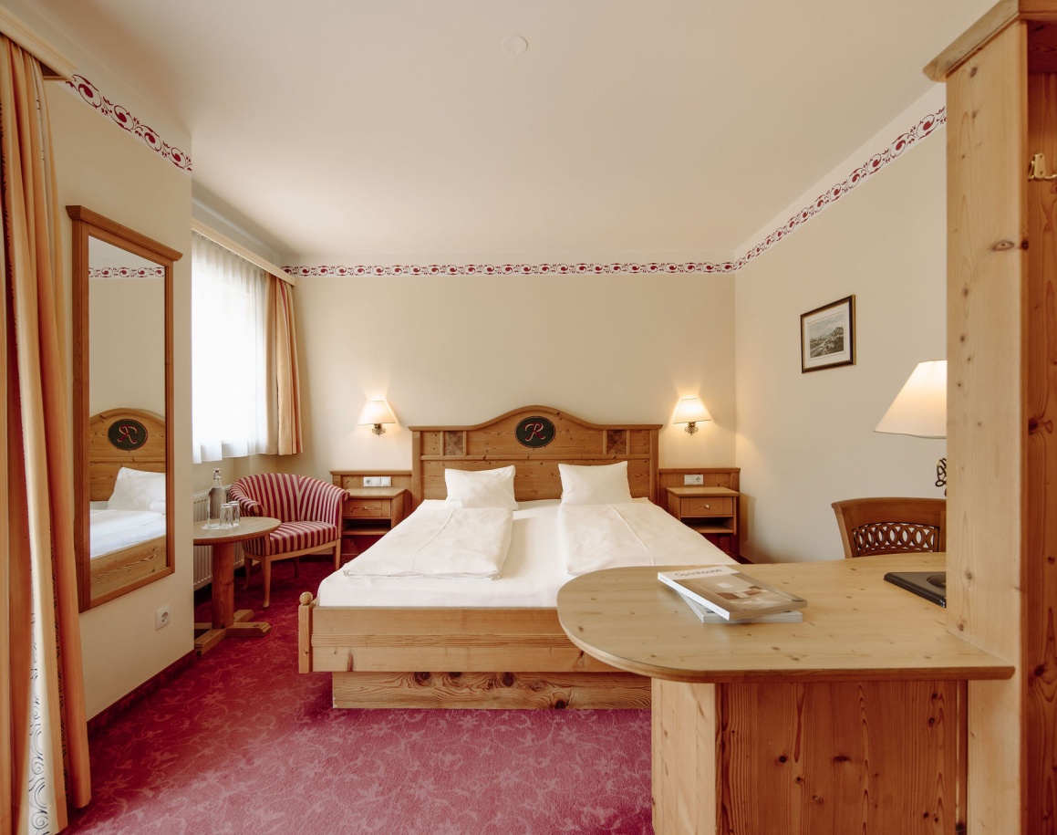 Resl Double Small mit Doppelbett, Holzmöbeln und rotem Teppichboden