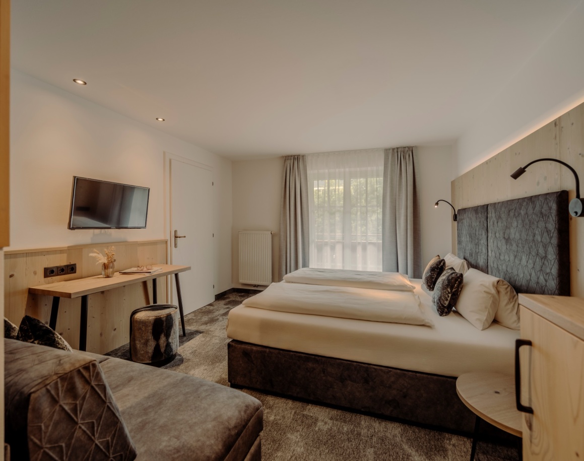 Modernes Hotelzimmer mit gemütlichem Doppelbett und Schreibtisch