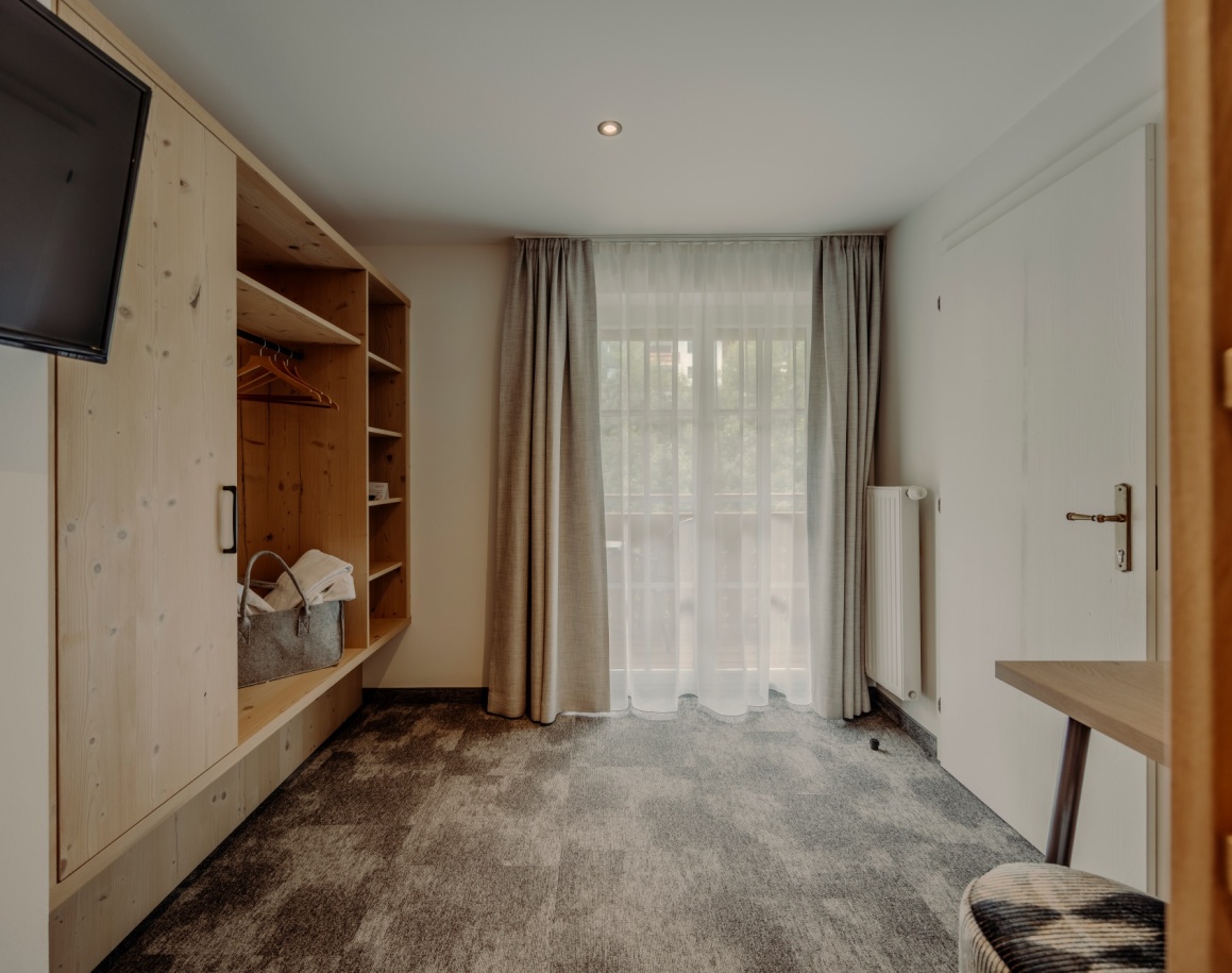 Helles Hotelzimmer mit Stockbett, Balkonblick und modernen Holzmöbeln