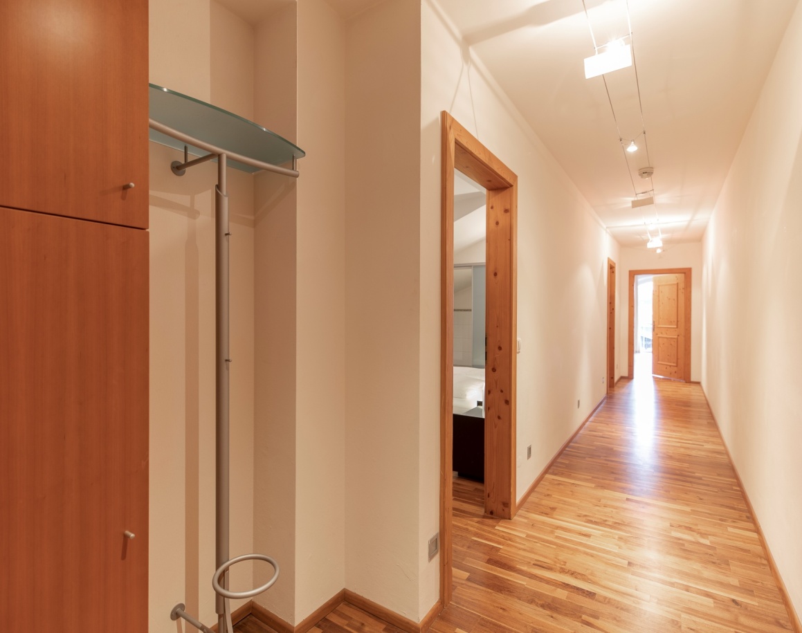 Langer, heller Flur mit Holzboden und Türen zu angrenzenden Räumen