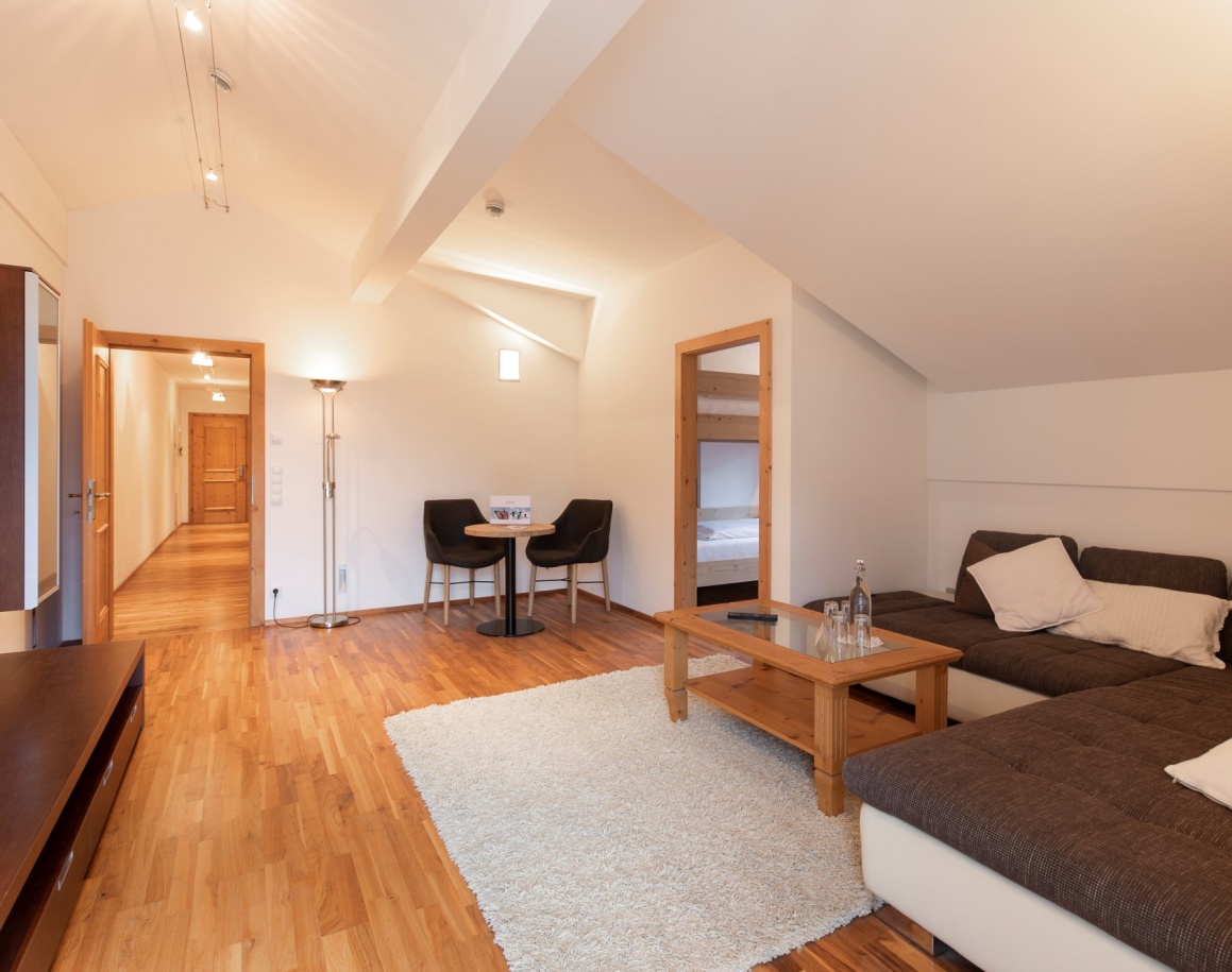 Wohnzimmer mit Parkettboden, Sofa und Teppich